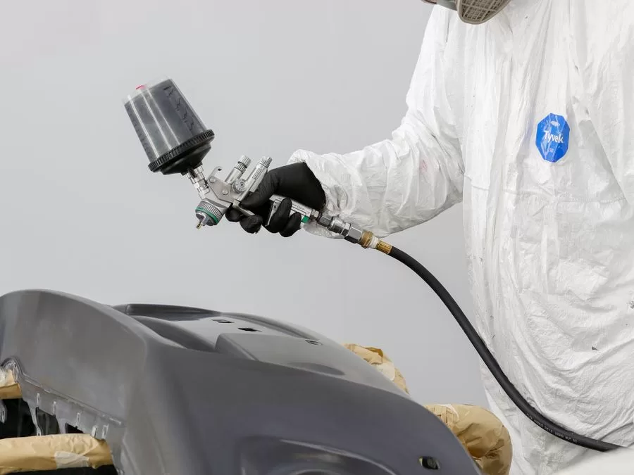 Mechanic performing professional bumper repair in an auto body shop