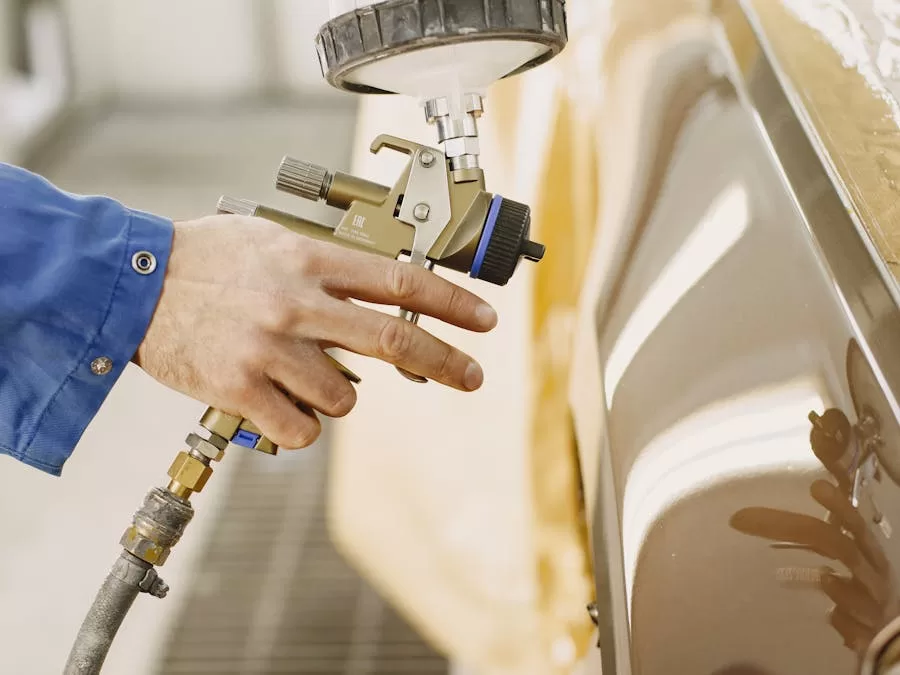 Auto technician spray painting a vehicle in a professional paint booth